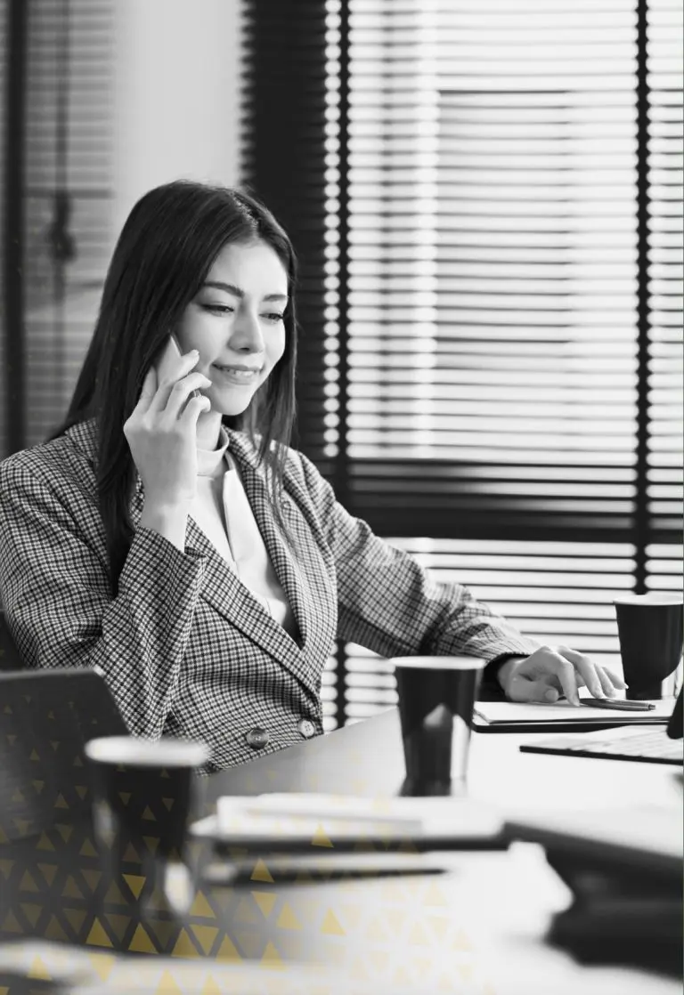 business woman on phone in front of laptop